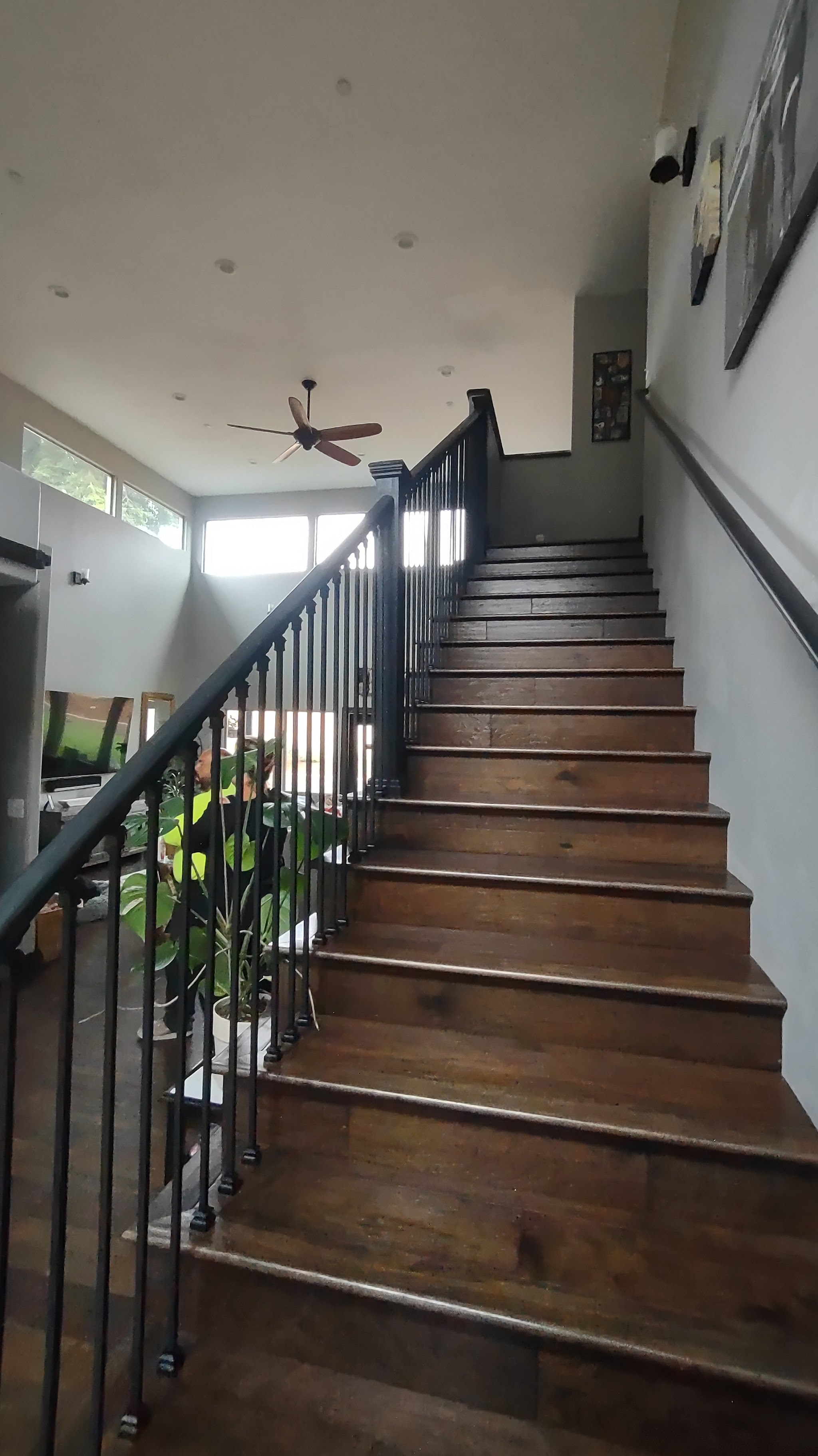 Finished interior staircase with dark wood treads and wrought-iron railing